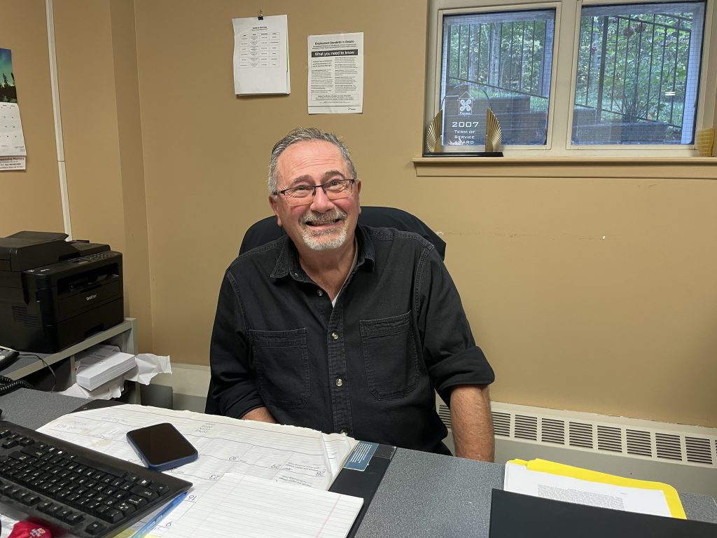 Middle age white make with glasses and a black button up shirt
